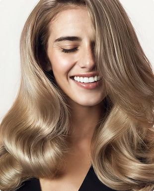 Model with blonde hair posing after using the Blacklight Blonde Science Repair Shampoo