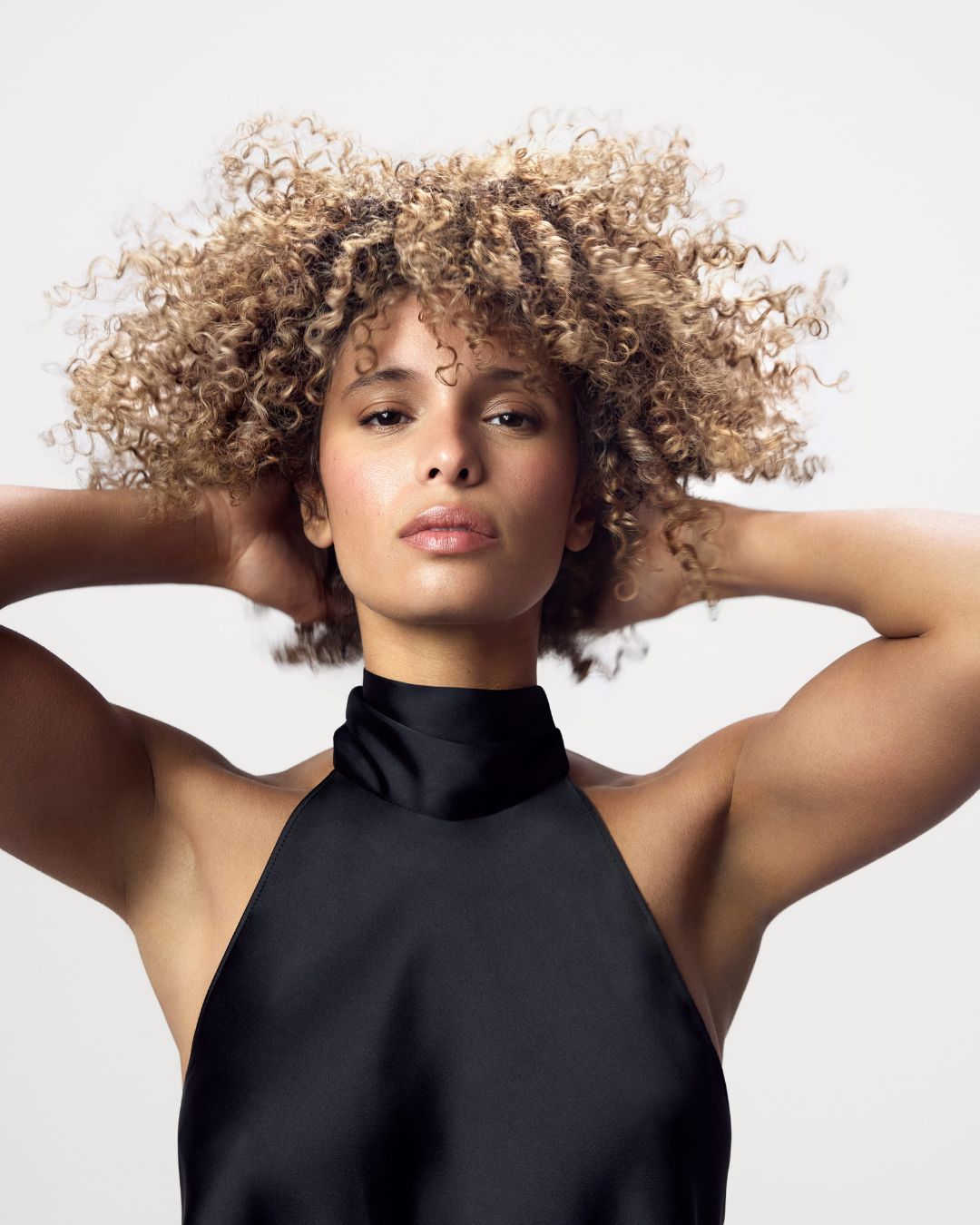Model posing in front of a white background after using the Blacklight Blonde Science Repair Hair Products