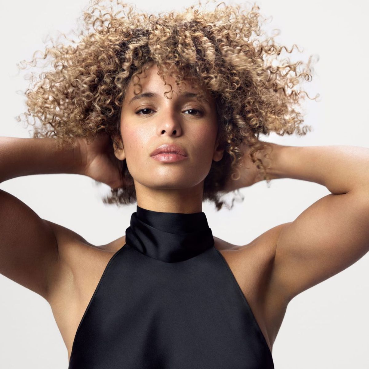 Model posing in front of a white background after using the Blacklight Blonde Science Violet Shampoo.